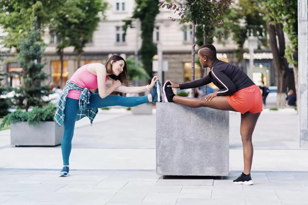 Twee jonge vrouwen die samen trainen op een stadsplein