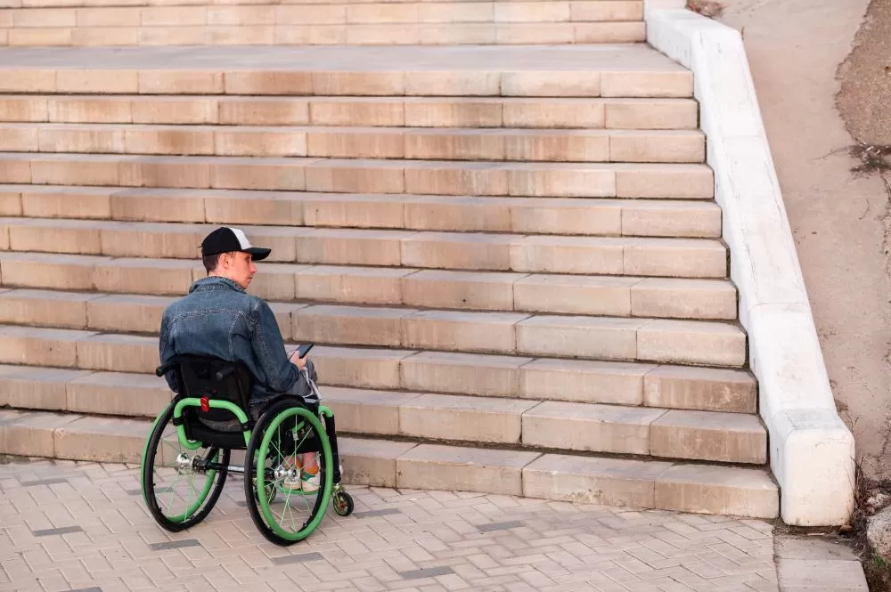 Een jongere in een rolstoel die de trap niet op kan