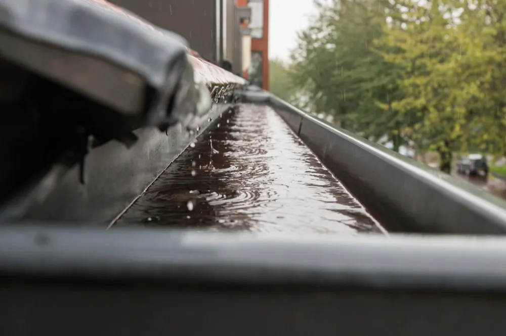 La pluie s'écoule du toit dans le tuyau d'évacuation