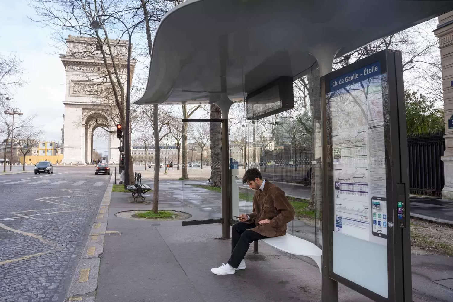 Jeune homme attendant l'arrêt de bus et utilisant son smartphone