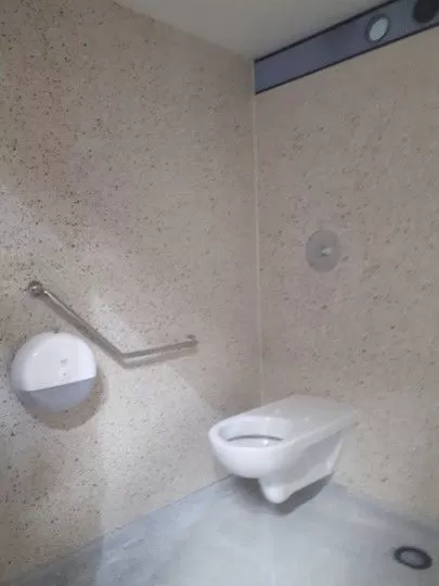Toilettes et barre PMR dans une cabine sanitaire