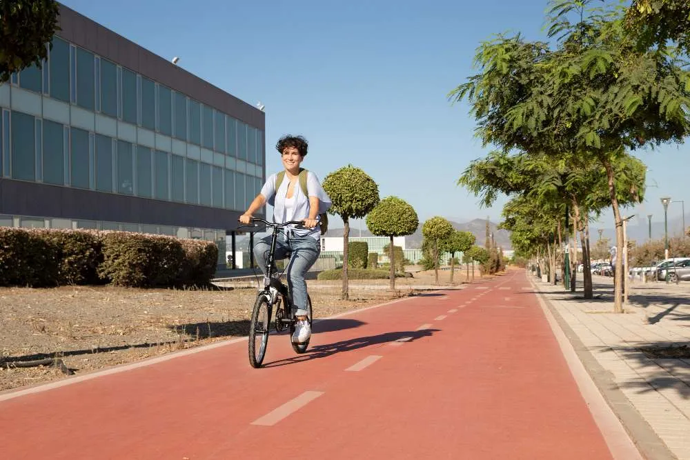 Comment favoriser la pratique du vélo en ville ? Jeune femme utilisant son vélo pliant