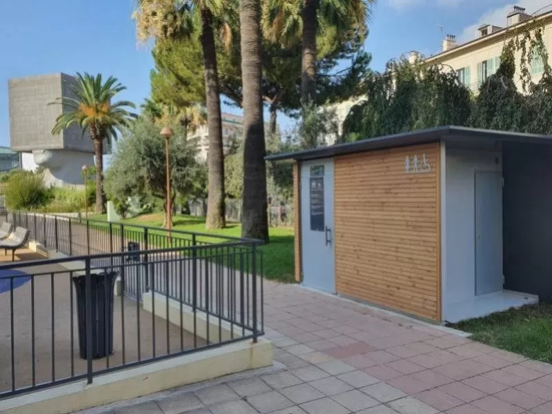 Sanitaires publics bois et gris dans un parc