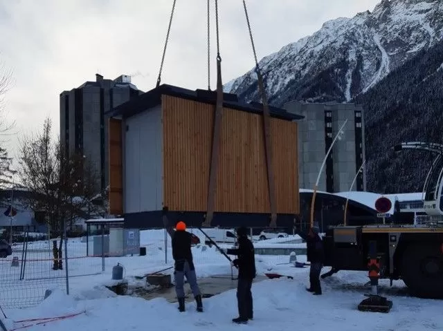 Sanitaires publics en cours d'installation sur une grue