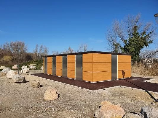 Sanitaires multi cabines avec façade en bois dans une zone d'activité